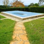 56523058-piscina-en-el-jardín-de-una-casa-de-campo-con-una-lona-de-protección-en-invierno